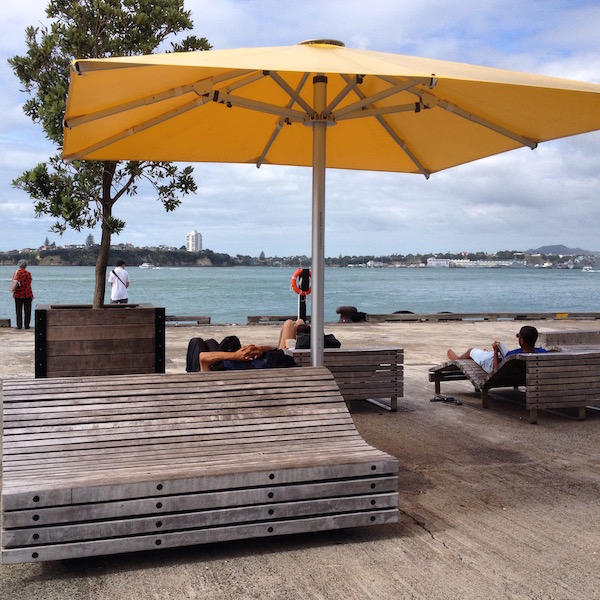 Grab a seat under the umbrella and enjoy a quiet afternoon at Queens Wharf, Auckland.